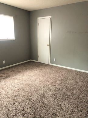 Abilene house for rent - A room with a carpeted floor and a white door.