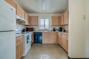 Watertown apartment for rent - a kitchen with white appliances and wooden cabinets