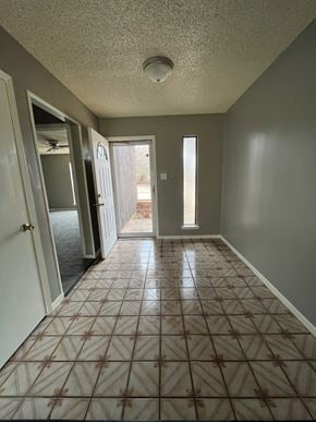 Abilene house for rent - an empty living room with a tiled floor and a door to a yard