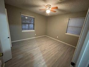 Abilene house for rent - A room with a ceiling fan and two windows.