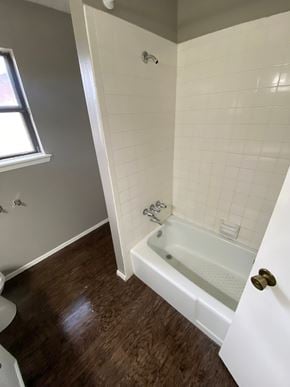 Abilene house for rent - A white bathroom with a tub and toilet.