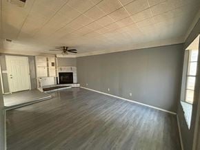 Abilene house for rent - an empty living room with wood floors and a ceiling fan