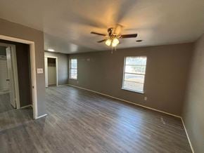 Abilene house for rent - an empty living room with wood floors and a ceiling fan