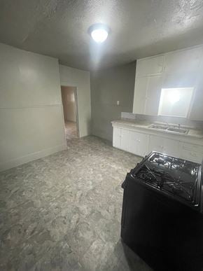 Abilene apartment for rent - A black stove in a room with a grey floor and white walls.