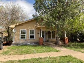 Abilene apartment for rent - A small house with a porch and a tree in front.