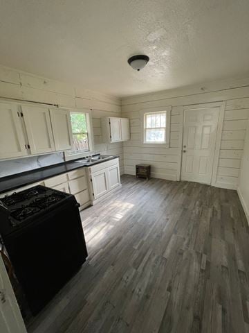 Abilene apartment for rent - A kitchen with a black stove top oven and wooden floors.