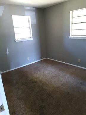 Abilene apartment for rent - an empty room with a carpeted floor and two windows