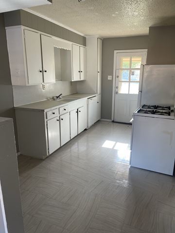 Abilene apartment for rent - an empty kitchen with white cabinets and stainless steel appliances