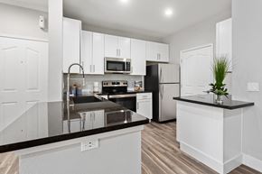Scottsdale apartment for rent - a kitchen with white cabinets and black counter tops