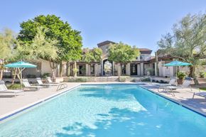 Scottsdale apartment for rent - a swimming pool with chairs and umbrellas in front of a house