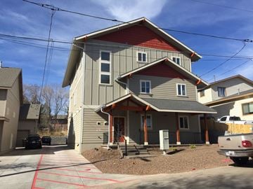 Flagstaff apartment for rent - a gray house with a red roof and a driveway