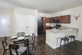 Austin apartment for rent - A kitchen with a table set for two and a black fridge.