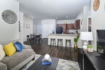 Austin apartment for rent - A living room with a grey couch and a wooden floor.