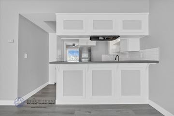 Redondo Beach apartment for rent - a white kitchen with white cabinets and a black counter top