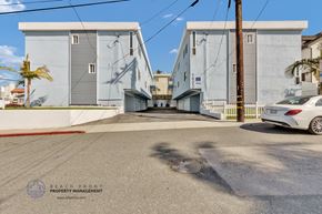 Redondo Beach apartment for rent - a white car is parked on a street in front of buildings