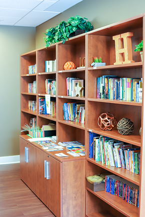 Baltimore apartment for rent - a childrens library with wooden bookshelves and a table with books