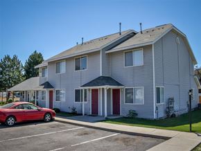 Weiser apartment for rent - a white apartment building with a red car parked in front