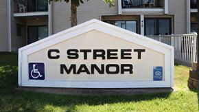 Rupert apartment for rent - a sign for c street manor in front of a house
