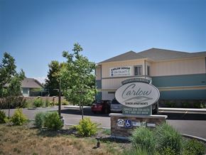 Rexburg apartment for rent - a building with a sign in front of a parking lot