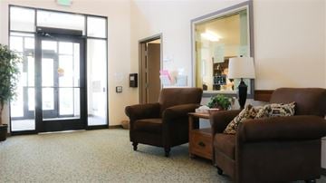 Rexburg apartment for rent - a living room with two brown chairs and a mirror