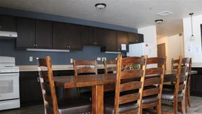 Rexburg apartment for rent - a kitchen with a wooden table and chairs