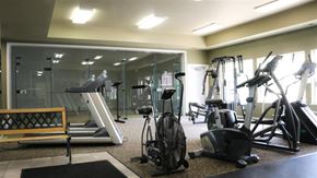 Boise apartment for rent - a gym with various exercise equipment and a glass wall