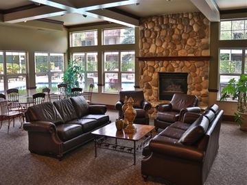 Boise apartment for rent - a large living room with leather furniture and a stone fireplace
