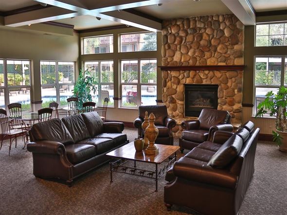 Boise apartment for rent - a large living room with leather furniture and a stone fireplace