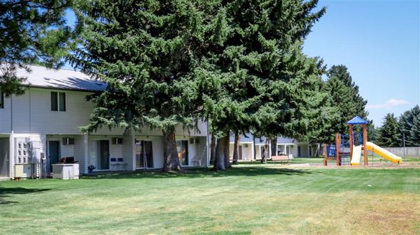 Burley apartment for rent - a building with a playground and a tree in front of it