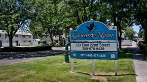 Burley apartment for rent - a blue sign sitting in the grass next to a street