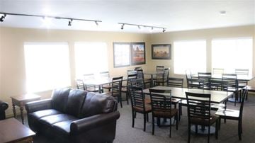 Rexburg apartment for rent - a living room with tables and chairs and a leather couch