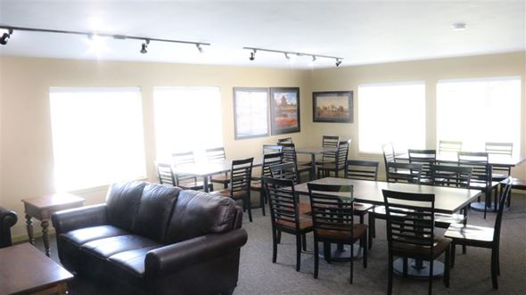 Rexburg apartment for rent - a living room with tables and chairs and a leather couch