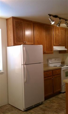Moscow apartment for rent - a white refrigerator in a kitchen with wooden cabinets