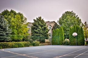 Boise apartment for rent - a basketball court in front of a house with trees