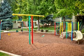 Boise apartment for rent - a playground with a slide and monkey bars in front of a house