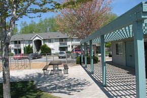 Garden City apartment for rent - a patio with a picnic table in front of an apartment building
