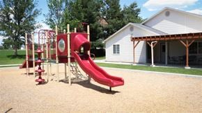 Mountain Home apartment for rent - a playground with a swing set and slides in front of a house