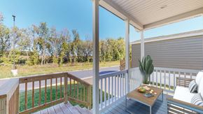 Oronoco apartment for rent - a covered porch with a table and chairs and a view of a yard and trees