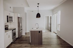 Grand Rapids apartment for rent - a kitchen with white cabinets and stainless steel appliances and a wooden floor