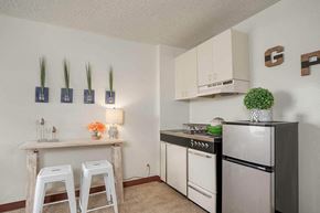 N. Tonawanda apartment for rent - a kitchen with a refrigerator and a counter with two bar stools