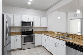 Orlando apartment for rent - a kitchen with white cabinets and stainless steel appliances