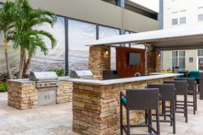 Orlando apartment for rent - a bar with chairs and a grill outside of a building