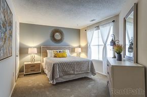 Denver apartment for rent - a bedroom with a bed and a dresser and a window