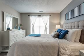 Denver apartment for rent - a bedroom with a large bed and a dresser