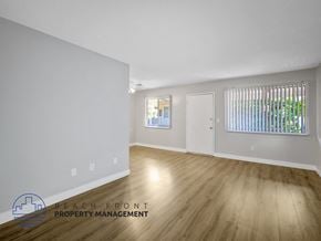 Long Beach apartment for rent - A room with wooden flooring and white walls, with a window covered by vertical blinds.