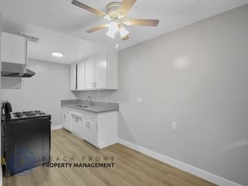 Long Beach apartment for rent - A kitchen with a stove top oven and a fan on the ceiling.