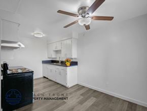 Long Beach apartment for rent - A kitchen with a ceiling fan and a logo that says Beach Front Property Management.