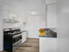 Long Beach apartment for rent - A modern kitchen with a black stove top oven and white cabinets.
