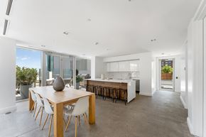 Jersey City apartment for rent - A modern kitchen with a dining table and chairs is shown.