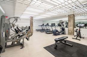 Jersey City apartment for rent - A gym with a variety of equipment including treadmills, stationary bikes, and weight machines.